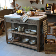 Grimaud szervírozóasztal rusztikus konyhában, márványlappal és tányérokkal dekorálva.