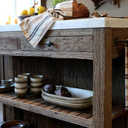 Grimaud szervírozóasztal részlet: fa fiókok, rusztikus polcok, elegáns fehér márvány fedlap.