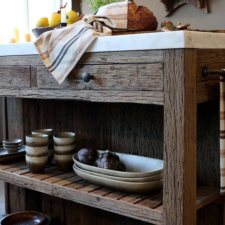 Grimaud szervírozóasztal részlet: fa fiókok, rusztikus polcok, elegáns fehér márvány fedlap.