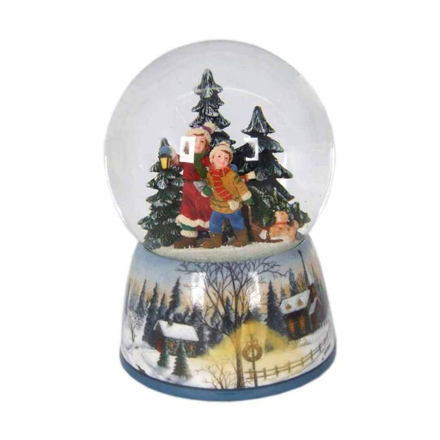 Karácsonyi zenélő hógömb, téli erdőben sétáló gyerekekkel.