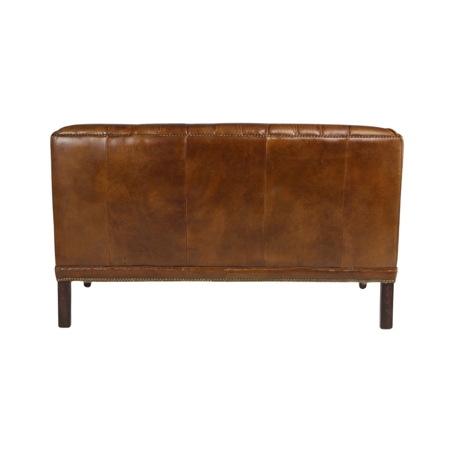 Bőrkanapé hátnézetből, sötétbarna fa lábakkal és vintage stílusú hátkialakítással