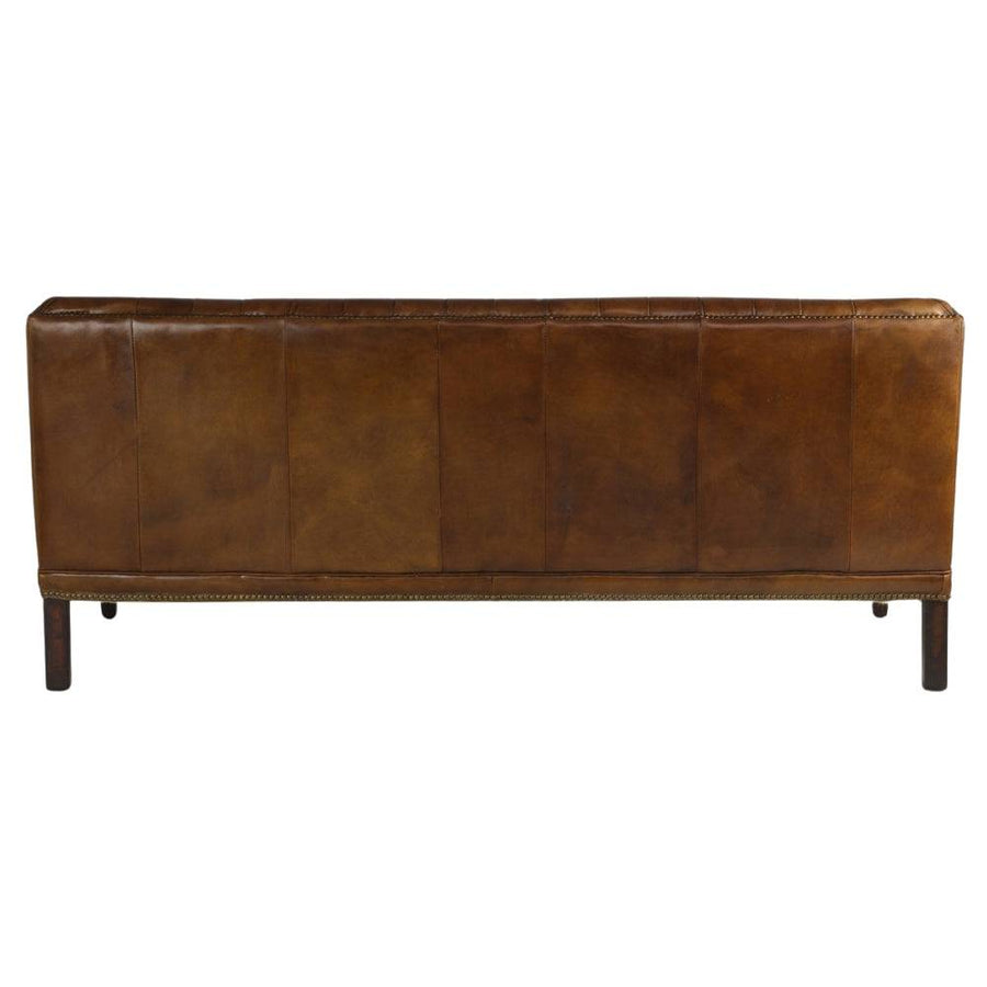 Bőrkanapé hátnézete sima bőrfelülettel és sötétbarna fa lábakkal