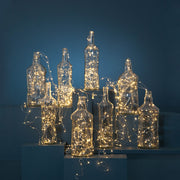 LED-es fényfüzér üvegpalackokban.