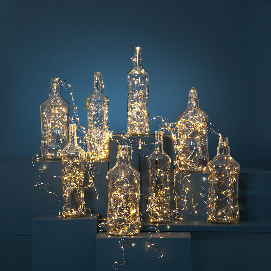 LED-es fényfüzér üvegpalackokban.