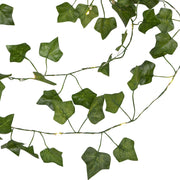 Közelről fotózott Hedera LED-es mű borostyán girland, zöld levelekkel és apró, meleg fehér fényű LED világítással fehér háttér előtt.