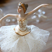 A First Snow balerina kézzel festett arcának, aranymintás ruhájának és csillogó pöttyös tüllszoknyájának közeli részlete.