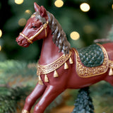 Közelkép a NOÉL bordó karácsonyi hintaló arany díszítésű nyergéről és kantárjáról