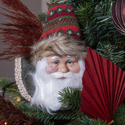 Vintage stílusú Télapó figura karácsonyfadíszként, fenyőágak között elhelyezve