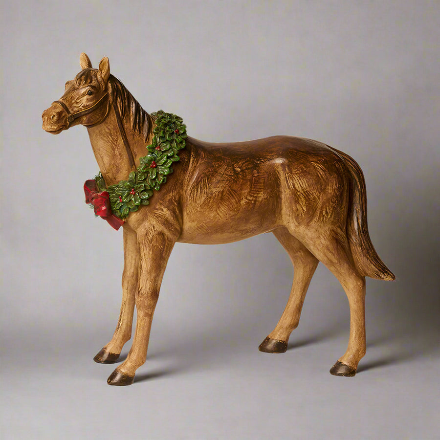 Ünnepi koszorúval díszített, barna színű, karácsonyi dekor lovacska.