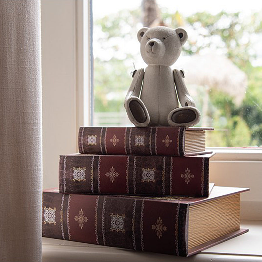 A Clayre & Eef krém mackó figura ablakpárkányon könyvek tetején.