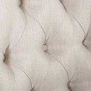 Közelkép a gombos tűzésű bézs kárpitozásról a HERITAGE fotel háttámláján.