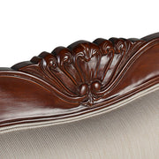 Részletfotó a kanapé háttámlájának kézzel faragott díszítéséről.