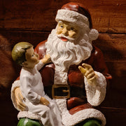 Vintage stílusú Mikulás figura ölében ülő kisfiúval