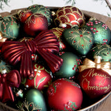 Zöld gyöngyös levélmintájú Heritage üveggömb más növényi mintás díszek és zöld szívdísz társaságában.