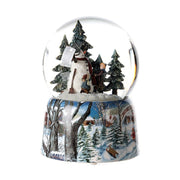 Karácsonyi zenélő-forgó hógömb, téli havas erdőben hóembert építő gyerekekkel.