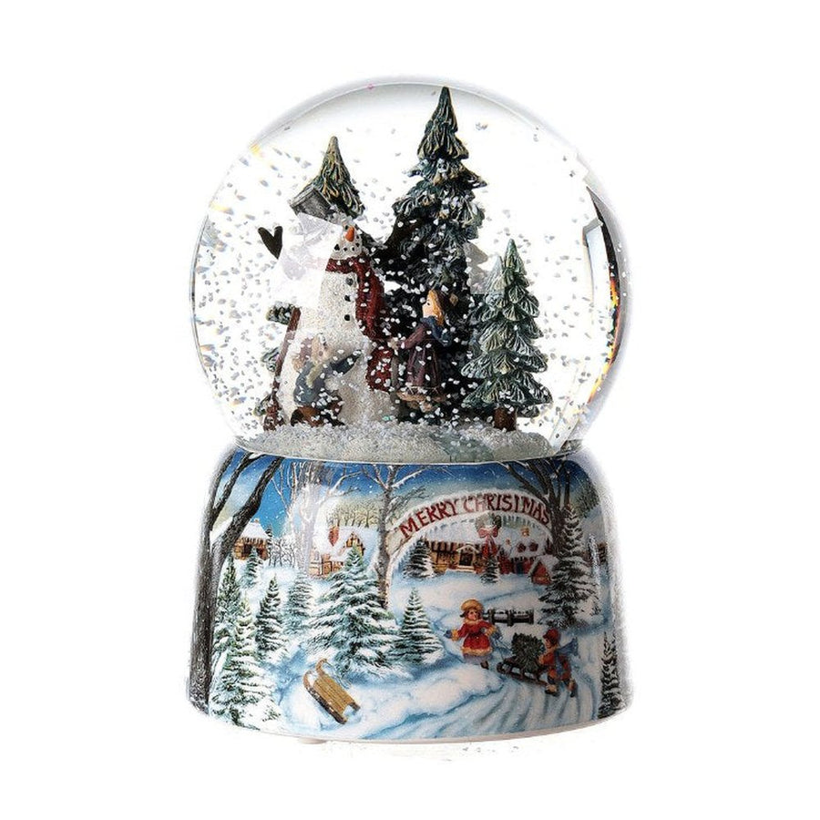 Karácsonyi zenélő-forgó hógömb, téli havas erdőben hóembert építő gyerekekkel.