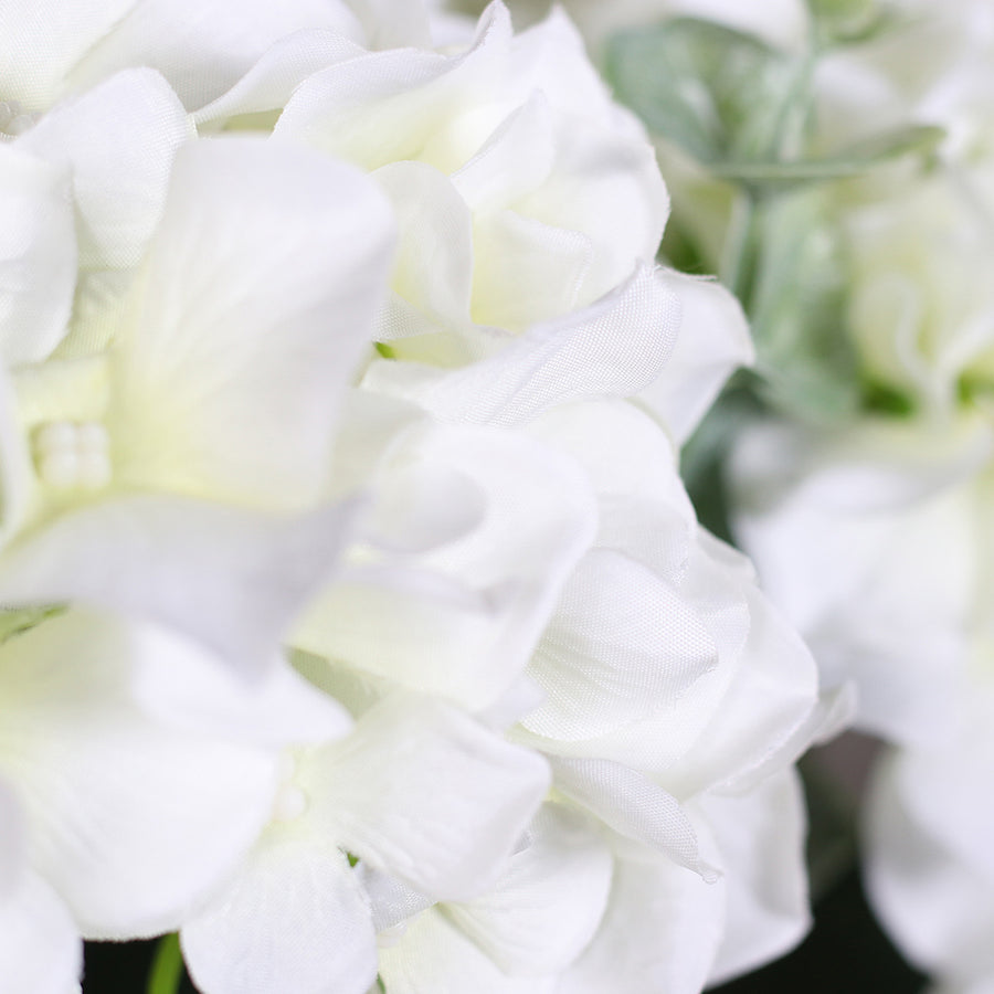 Víztiszta üvegvázában kialakított, krémszínű mű hortenzia virágcsokor.