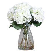 Víztiszta üvegvázában kialakított, krémszínű mű hortenzia virágcsokor.