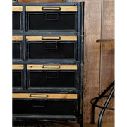 Fekete színű vasból és natúr színű fenyőfából készült 11 fiókos komód.