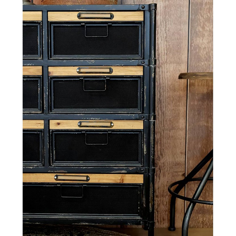 Fekete színű vasból és natúr színű fenyőfából készült 11 fiókos komód.