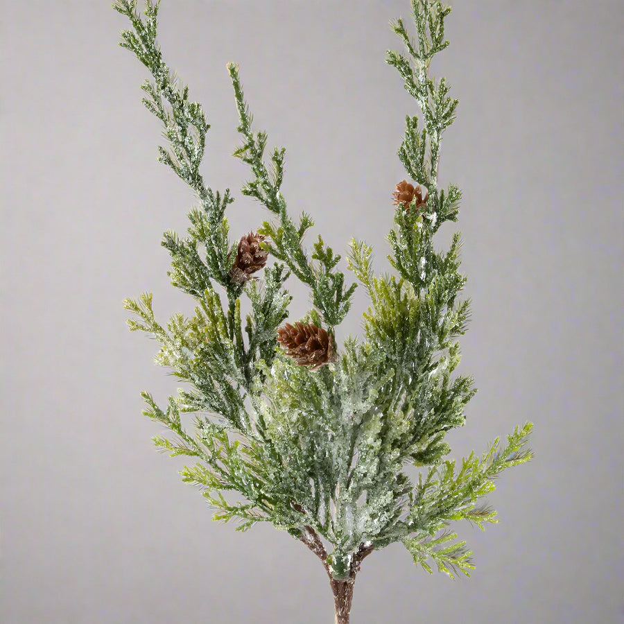 43 cm magas mű borókafenyő ág havas bevonattal, élethű megjelenéssel és dekoratív barna tobozokkal.