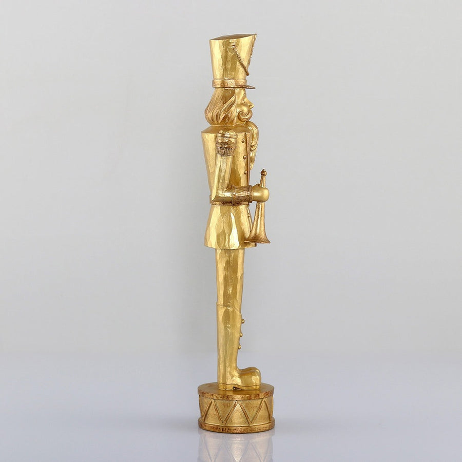 Arany színárnyalatú, faragott fahatású karácsonyi diótörő figura.