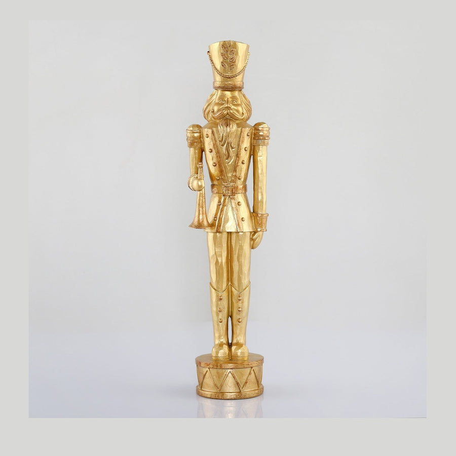 Arany színárnyalatú, faragott fahatású karácsonyi diótörő figura.