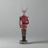 Plüssmackót tartó karácsonyi szarvas figura.