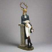 Oszlopnak támaszkodó, szarvas figura.