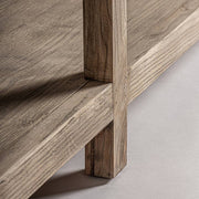 Lábrészlet: Masein vitrines szekrény natúr szilfa lába és alsó polca közelről.