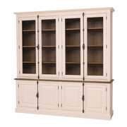 Világos bézs MAISON vitrines fenyőfa könyvszekrény sötét fa hátlappal és díszes fekete rúdzáras fogantyúkkal, klasszikus kazettás ajtófronttal.