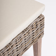 Közeli fotó a MANOEL étkezőszék ülőpárnájáról és fonott rattan részleteiről.