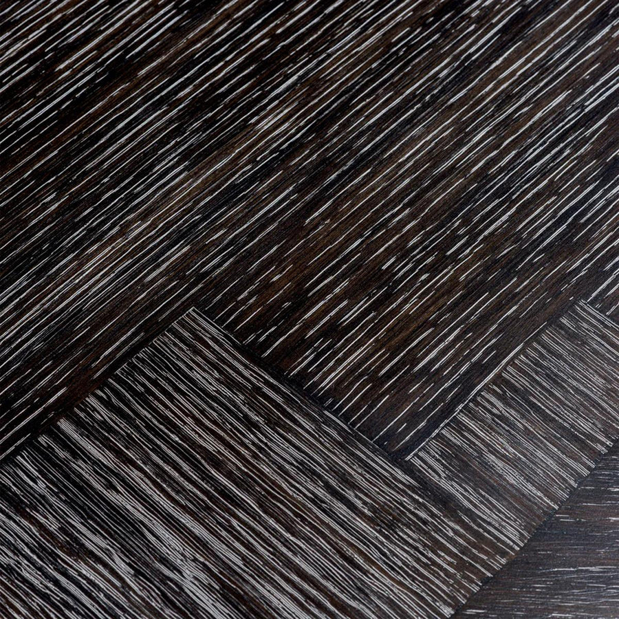 Faszénfekete színű tölgyfurnérból és bronz felületű rozsdamentes acélból készült, ovális formájú design étkezőasztal.