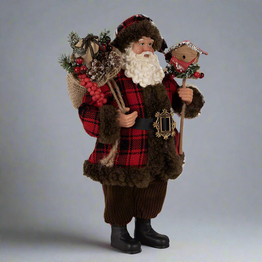Ajándékot hozó, bordó színű Mikulás figura.