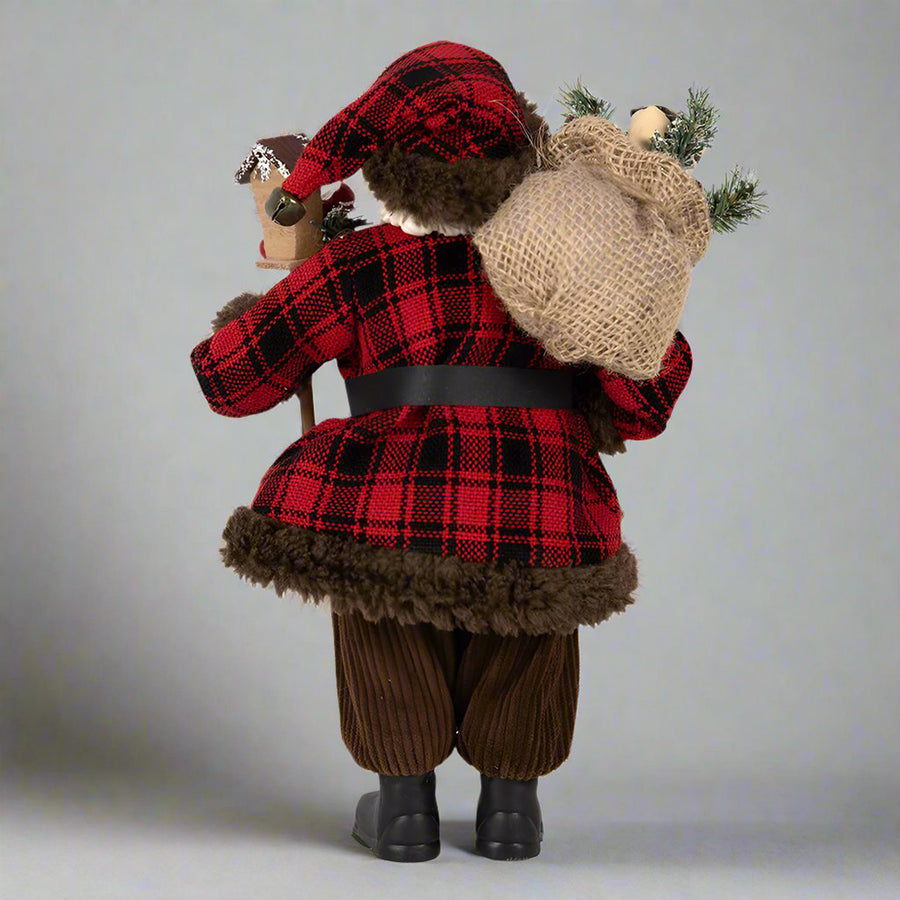 Ajándékot hozó, bordó színű Mikulás figura.