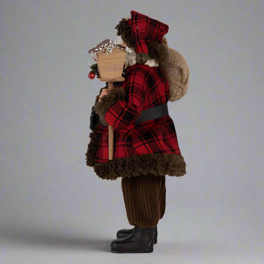 Ajándékot hozó, bordó színű Mikulás figura.