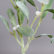 Karácsonyi dekorációhoz készült mű fagyöngy ág fehér bogyókkal és élethű zöld levelekkel.