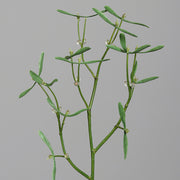 Részletfotó mű fagyöngy ágról zöld levelekkel és fehér bogyókkal, élethű kidolgozásban.