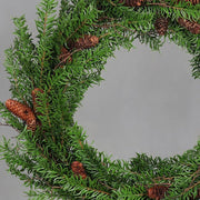Mesterséges nobilis fenyőágakból készült, tobozokkal díszített ajtódísz koszorú.