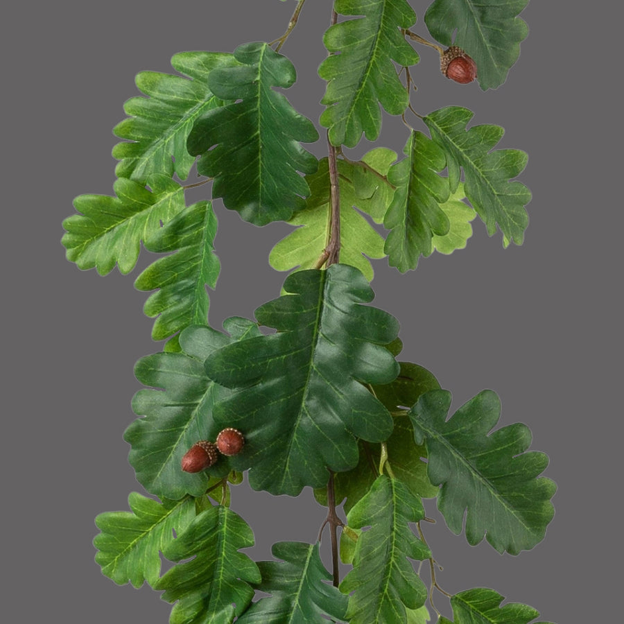 Makkokkal díszített, zöld színű, tölgyfaleveles girland műnövény.