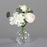 Krémszínű, vegyes művirágokból készült virágcsokor üvegvázában..