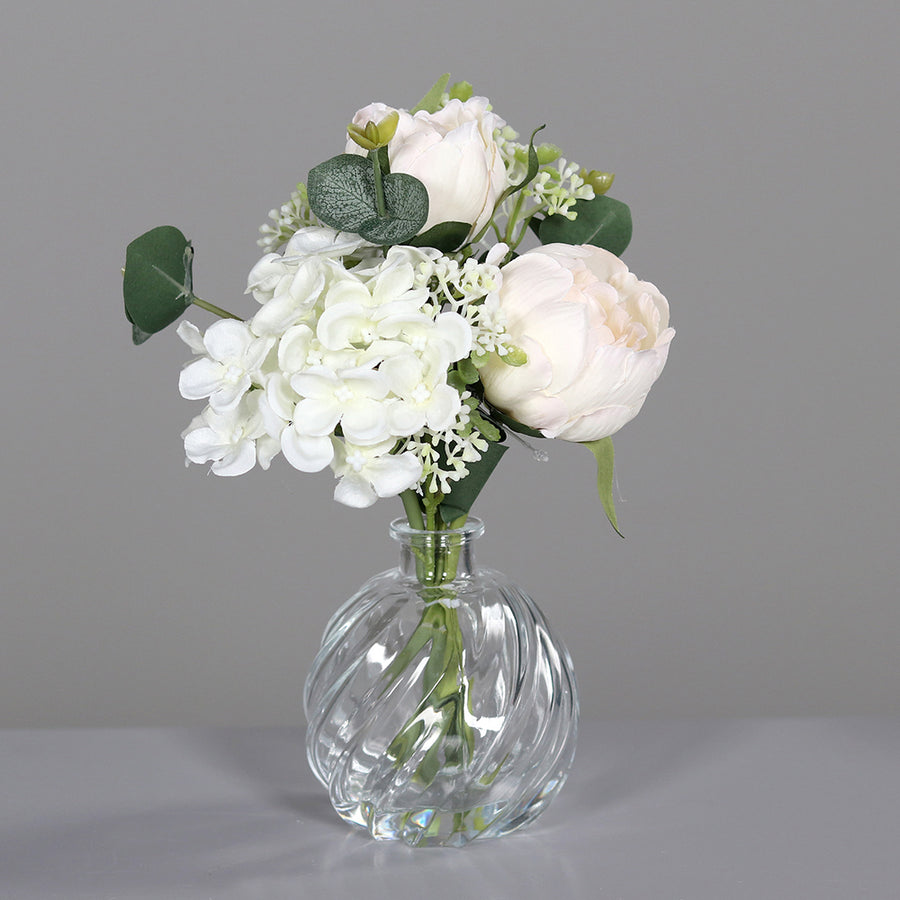 Krémszínű, vegyes művirágokból készült virágcsokor üvegvázában..