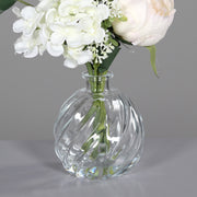 Krémszínű, vegyes művirágokból készült virágcsokor üvegvázában..