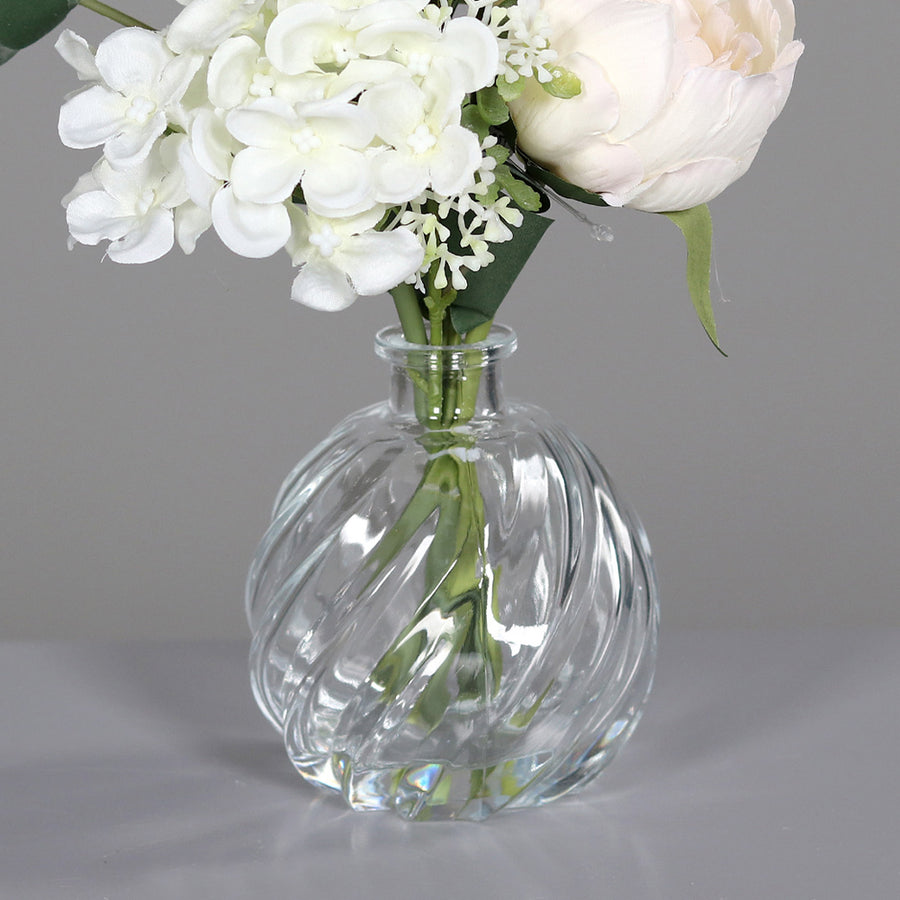 Krémszínű, vegyes művirágokból készült virágcsokor üvegvázában..