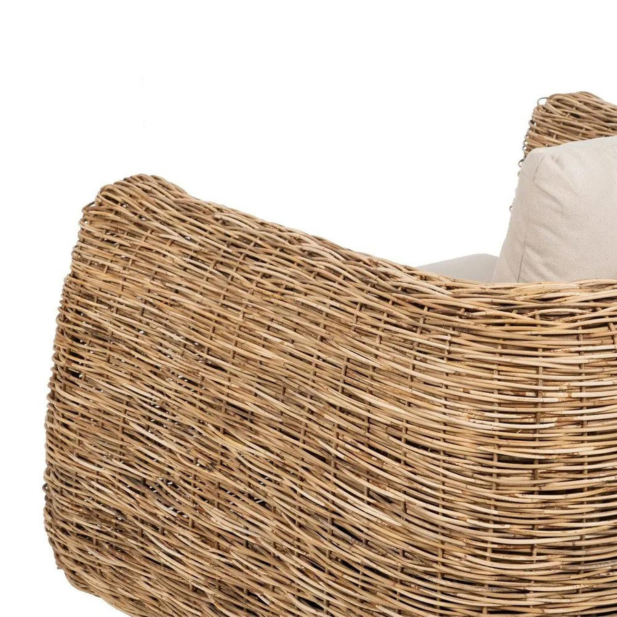 Natúr színű, formatervezett rattan fotel, ekrü párnákkal.