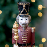 Közelkép a bordó diótörő arany gombos egyenruhájáról és fekete kalapjáról