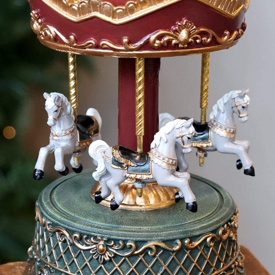 Közelkép a zenélő körhinta fehér lovairól és arany díszítéséről