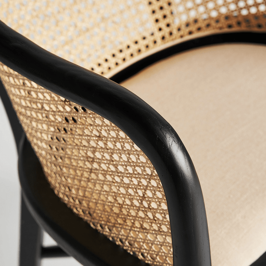 Nuchis karosszék részlet, fekete fa karfa és rattan háttámla találkozása