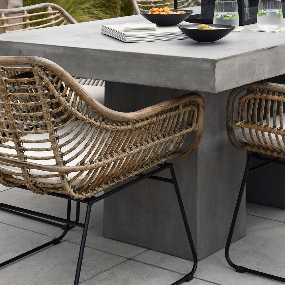 Fonott rattan kerti szék modern beton étkezőasztal mellett