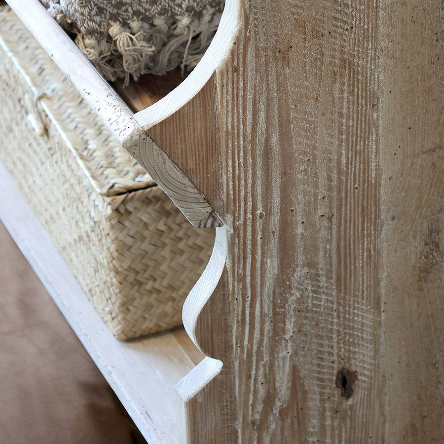 Kézzel faragott ívelt oldalelem a natúr fa bútor oldalán, karakteres rusztikus textúrával.